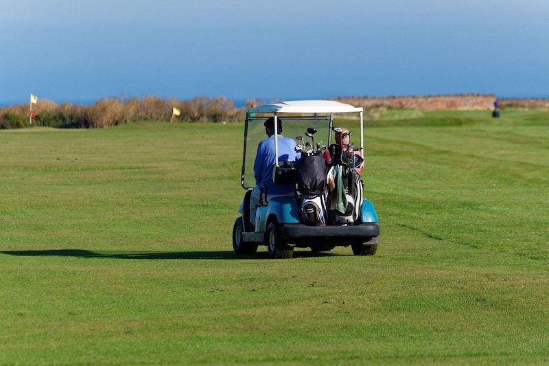 Golfspelare i golfbil reser med Golfhäftet